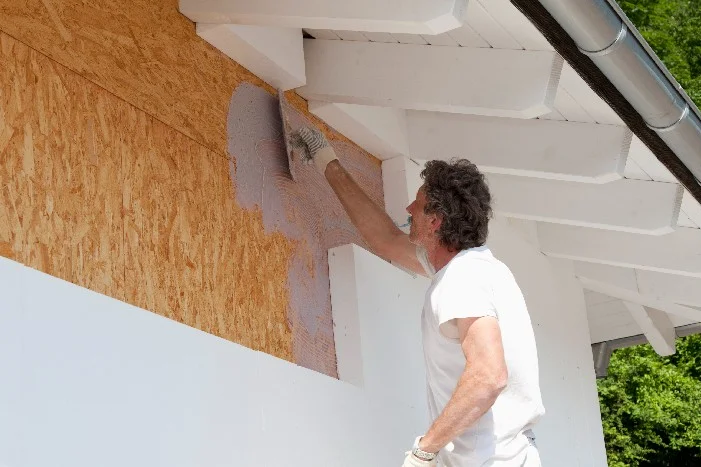 Person verputzt Hauswand